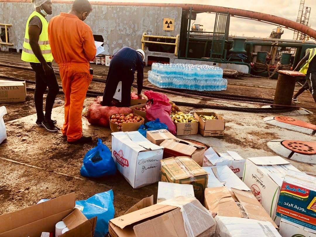 Equipe HHA en combinaisons orange - provisions fraîches sur pont au coucher de soleil